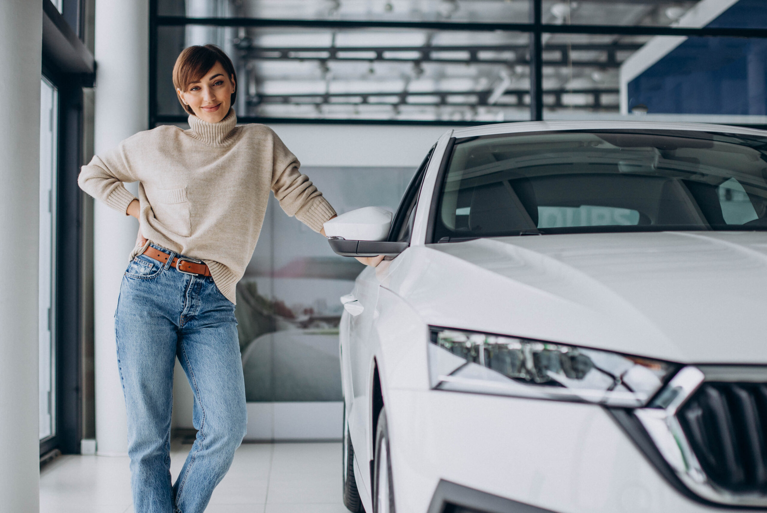 Woman in a car showroom choosing a new car